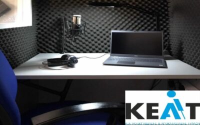 Φωτογραφία από το εσωτερικό ενός θαλάμου ηχογράφησης στα ανανεωμένα studio του ΚΕΑΤ. Απεικονίζεταιενας φοριτός υπολογιστής, ένα επαγγελματικό μικρόφωνο, ακουστικά και κάρτα ήχου πάνω σε γραφείο.