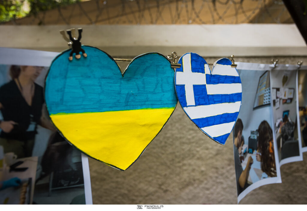 Δύο χάρτινες καρδιές, η μία δίπλα στην άλλη, μέσα στις οποίες, τα παιδιά που φιλοξενούνται στον ξενώνα "Ιρίνα", έχουν ζωγραφίσει τις σημαίες της Ελλάδας και της Ουκρανίας. 