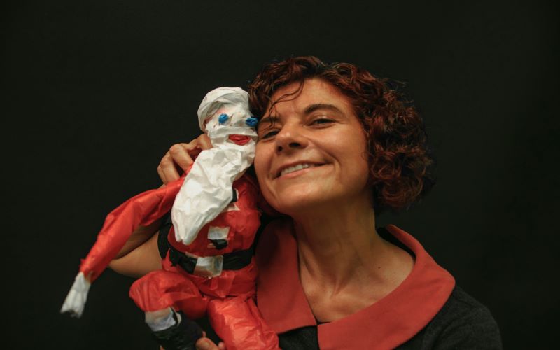 Φωτογραφία της εκπαιδεύτριας θεάτρου κούκλας, Εμμανουέλας Καποκάκη, η οποία ποζάρει με κούκλα που απεικονίζει τον Άγιο Βασίλη.