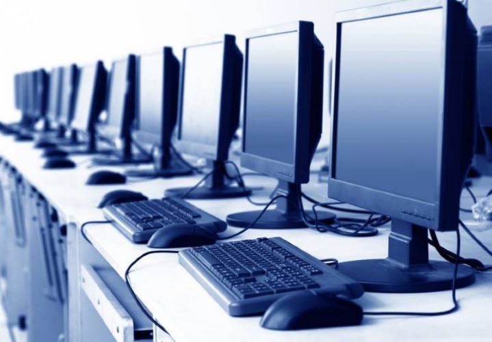 Οθόνες ηλεκτρονικών υπολογιστών και πληκτρολόγια πάνω σε γραφεία.