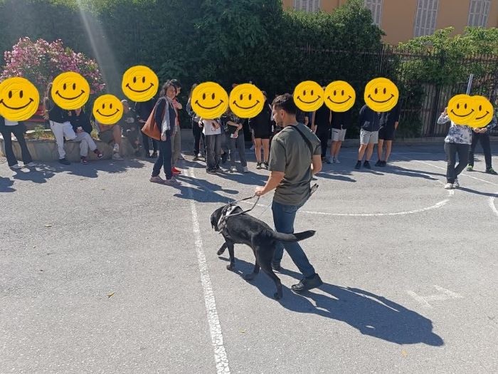 Οι μαθητές από το 6ο Γυμνάσιο Θεσσαλονίκης παρακολουθούν στο προαύλιο χώρο του σχολείου τους μια διαδρομή του χειριστή με τον σκύλο οδηγό.