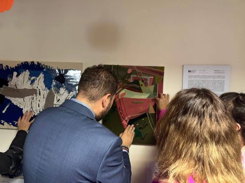 Ο Γενικός Γραμματέας Δημογραφικής και Στεγαστικής Πολιτικής του Υπουργείου Κοινωνικής Συνοχής και Οικογένειας, κ. Κωνσταντίνος Γλούμης - Ατσαλάκης αγγίζει με τα χέρια του ανάγλυφο εικαστικό έργο. Δίπλα του η Διοικήτρια του ΚΕΑΤ, κα Σοφία-Λευκή Χαμονικολάου.