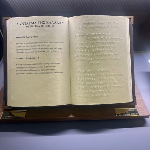 Στην έκθεση παρουσιάζεται και το απτικό βιβλίο με Braille που δημιούργησε το ΚΕΑΤ, το οποίο περιλαμβάνει σε προσβάσιμη, απτική μορφή τα άρθρα 21 και 25 του Συντάγματος που αφορούν τα δικαιώματα και την προστασία των ατόμων με αναπηρία.