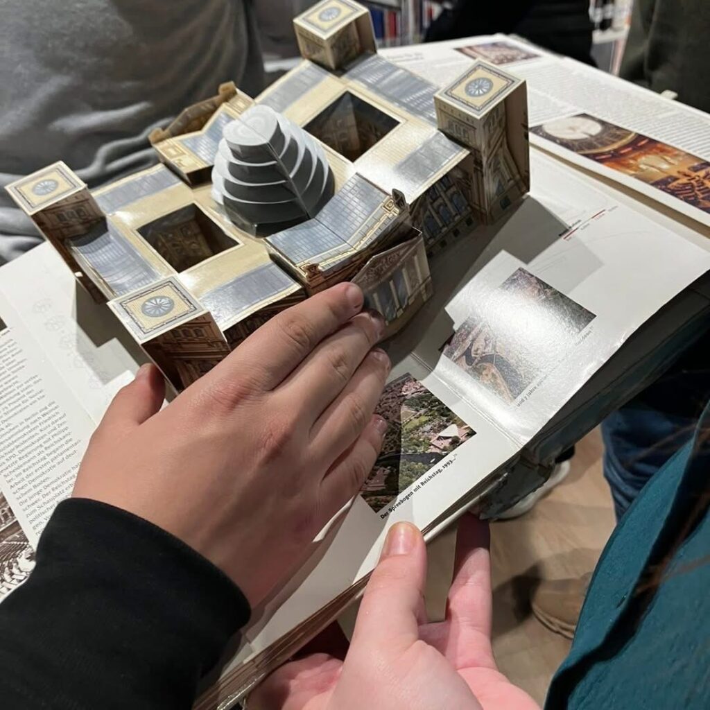 Η κα Vranos δώρισε στο Τμήμα Εκπαίδευσης τόμο με την ιστορία του Βερολίνου, στον οποίο μνημεία και κτίρια παρουσιάζονται σε τρισδιάστατη μορφή