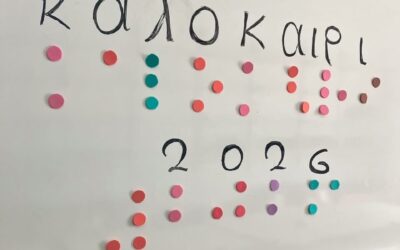 Σε ασπροπίνακα γραμμένο με πολύχρωμες κουκίδες braille και σε γραφή βλεπόντων «Καλοκαίρι 2026»