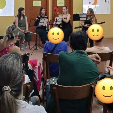 μαθητές και γονείς παρακολουθούν τη μίνι συναυλία πνευστών.